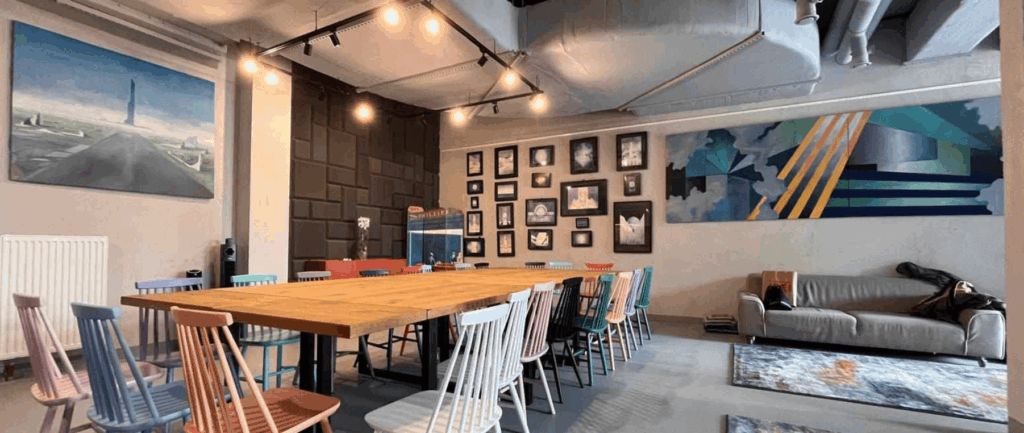 Creative studio-style event space with a long wooden table and colorful chairs