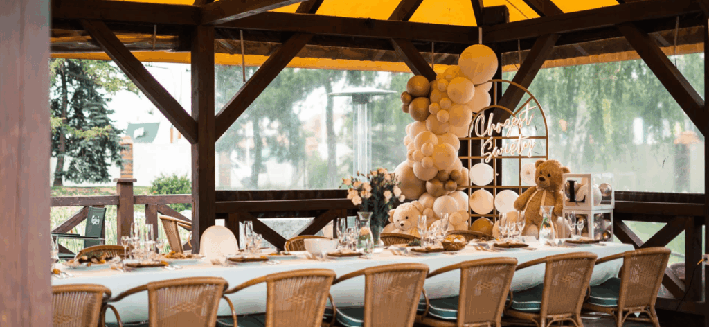 Outdoor dining setup with balloons and teddy bear decor for a celebration.Если хочешь, могу: