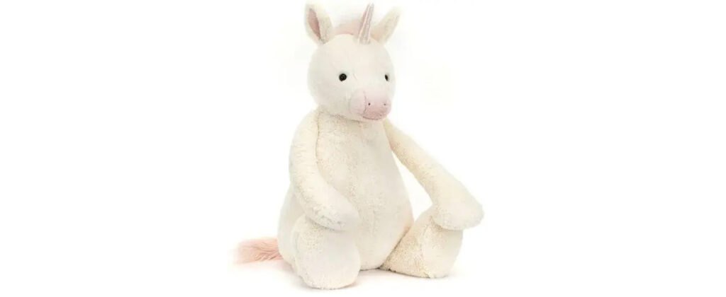Soft plush unicorn toy with pink horn and tail, designed as a cuddly stuffed animal for kids.